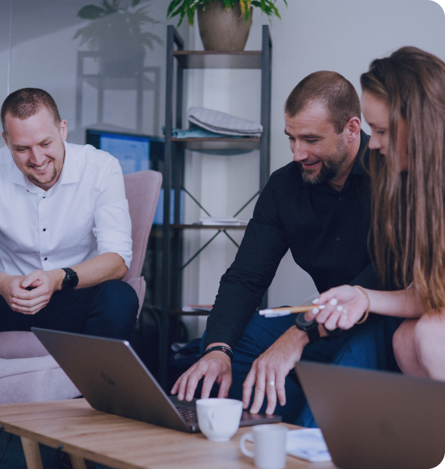 Three members of the Oriogo team working together at a laptop